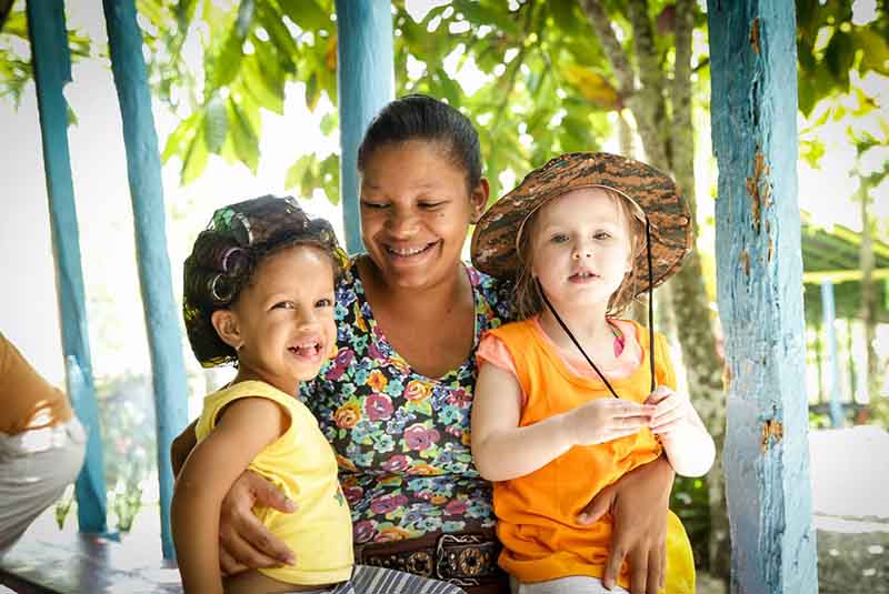 smiling local women and girl with foreign girl in Anamuya - Dominican Republic