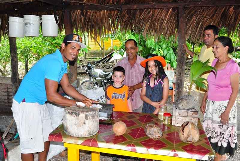 family visits coconut farmer to see process of coconut oil making