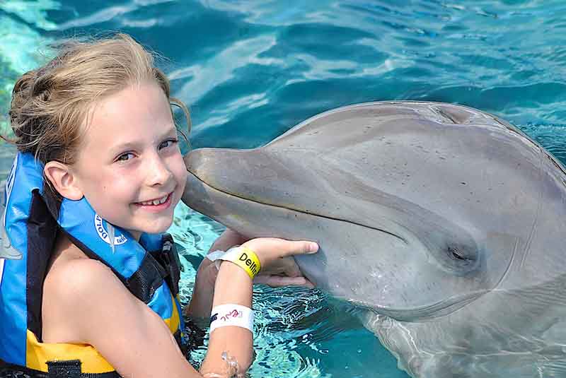 Girl receiving kiss by dolphin in Punta Cana - Dominican Republic