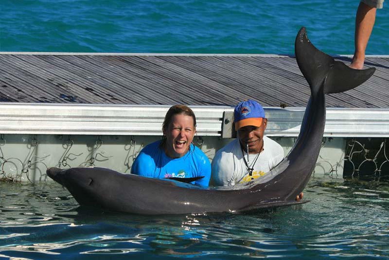 women interacting with dolphin and trainer in Punta Cana -Dominican Republic